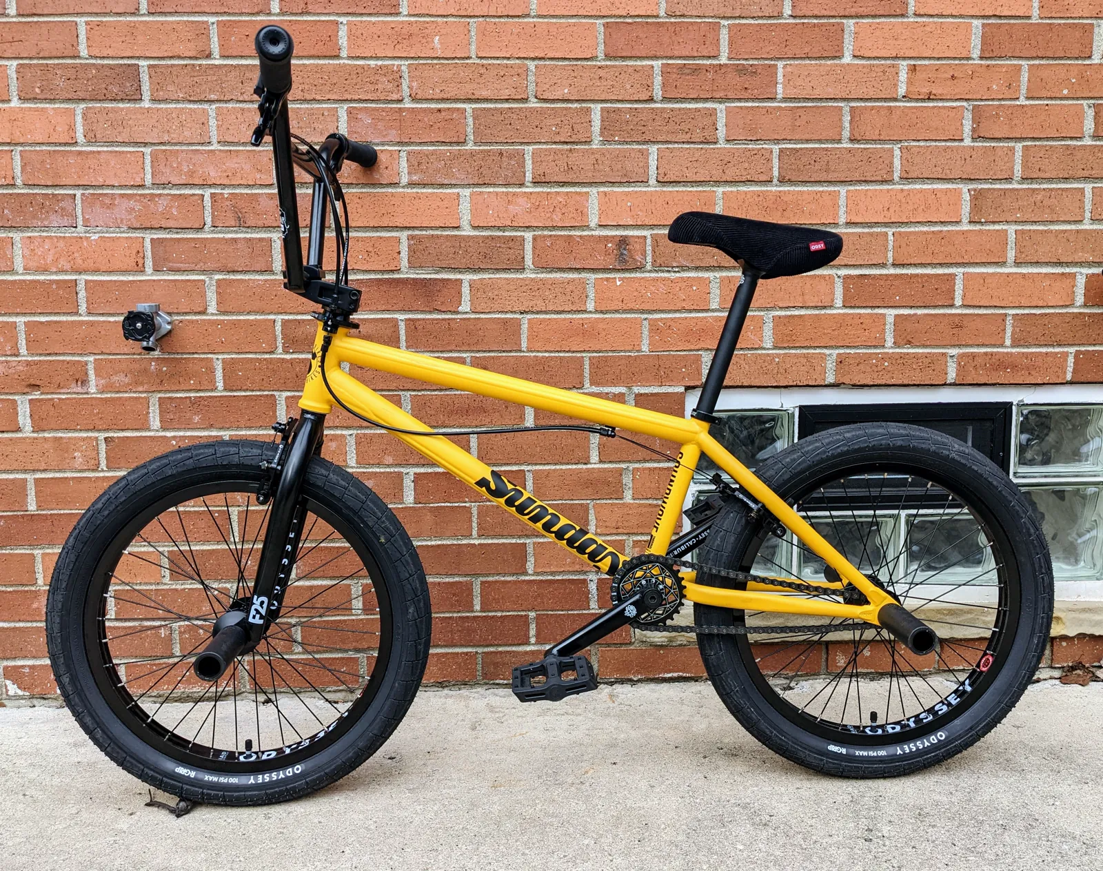 Final full side profile of the custom yellow-and-black 2021 Sunday Soundwave against a brick wall.